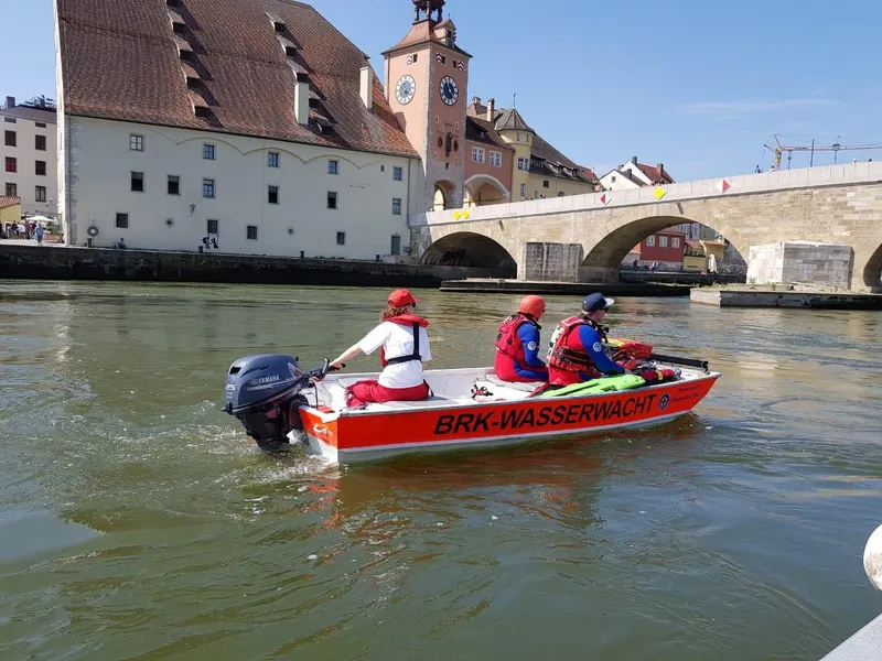 Jon-Boot 99/2 der Wasserwacht Regenstauf mit drei Einsatzkräften auf der Donau vor der Steinernen Brücke in Regensburg